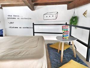 图兰辛戈Original y Cómodo Loft en el Centro de Tulancingo的一间卧室配有一张床、一张桌子和一张边桌