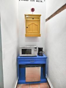 图兰辛戈Original y Cómodo Loft en el Centro de Tulancingo的一张蓝色桌子,配有微波炉和黄色橱柜