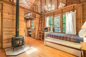 霍兰Deer Creek Cabin的小木屋内一间卧室配有燃木炉