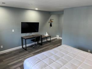 圣克鲁兹冲浪城套房汽车旅馆的一间卧室配有一张床和一张书桌及电视