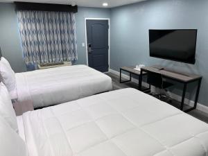 圣克鲁兹冲浪城套房汽车旅馆的酒店客房设有两张床和一台平面电视。