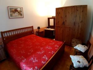 科马诺泰梅Casa Vacanze Cillà的一间卧室配有红色的床和木制橱柜