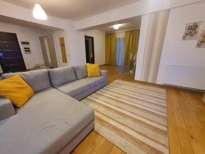 布加勒斯特Upground14 Residence Apartments的客厅配有灰色的沙发和黄色的枕头。