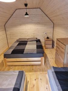 波别罗沃Domki Pod Dębami的木制客房内的一间卧室,配有一张床