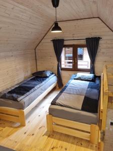 波别罗沃Domki Pod Dębami的木墙客房的两张床
