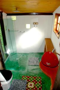 伊塔蒙蒂Pousada Estância Rio Acima的一间带红色卫生间和玻璃淋浴的浴室