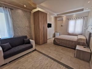 奇亚Villa Bianca的一间卧室配有一张床、一张沙发和一台电视。