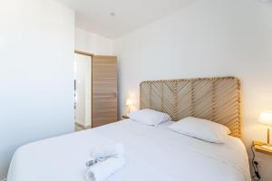 马赛Marseille: Superbe vue sur Notre-Dame de la Garde的卧室配有白色的床和2条毛巾