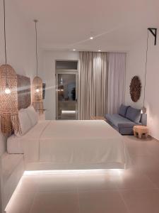 阿彻奇洛斯Delfini Beach Hotel & Suites的白色卧室设有一张大床和一张沙发