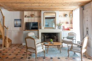 圣马丹德雷La Martinoise Patio的客厅设有壁炉、桌子和椅子
