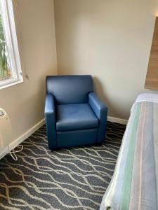 希尔斯伯勒希尔斯伯勒沙丘汽车旅馆的一张蓝色椅子,放在床边的房间