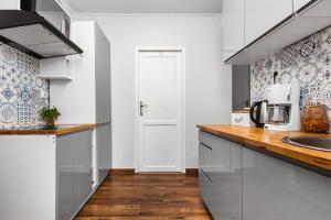 格丁尼亚Apartament Revel的厨房配有白色橱柜和木制台面