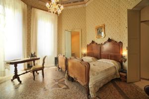 奥里斯塔诺Residenza d'Epoca Regina d'Arborea的一间卧室配有一张床、一张桌子和一张书桌