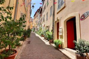 马赛La Sardine du Panier®的一条狭窄的街道,在建筑物两侧有植物