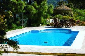 ComaresHotel B&B Finca la Loma的庭院内一个带桌椅的游泳池