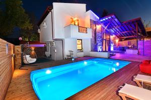 萨潘贾Nibras Villa Resort Hotel的夜间在房子前面的游泳池