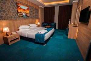 埃尔比勒Sipan Hotel的酒店客房,配有床和电视