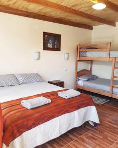 圣佩德罗·德·阿塔卡马Hostal Ckamai的一间卧室配有一张床和两张双层床。
