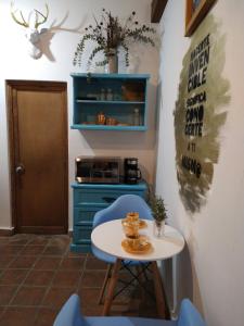 图兰辛戈Acogedor Loft amueblado en el Centro de Tulancingo的厨房配有一张桌子和椅子,厨房配有蓝色橱柜