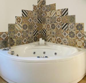 福尔米亚Sogno Mediterraneo的带浴缸的浴室和瓷砖墙