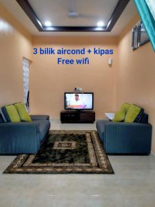 阿罗士打Rahman Homestay Pantai Johor - ISLAM SAHAJA的客厅配有2张蓝色沙发和电视