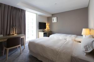 高雄麗馨商旅七賢館的酒店客房配有一张床、一张书桌和一台电视。