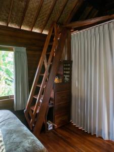 登巴萨Pondok Biu的一间卧室,卧室内设有木制楼梯