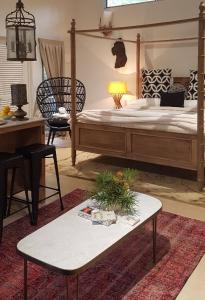 克拉佛斯Mt Lofty Botanic Garden Studio的一间卧室配有一张大床和一张桌子及四柱床