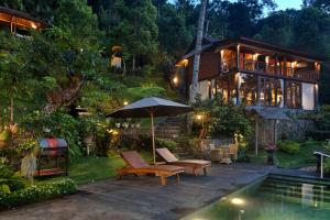 SerayaLoids Villa Eco Lodge Lempuyang的游泳池旁带遮阳伞的房子
