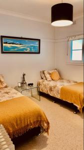 库塔曼德拉Parker st的一间卧室配有两张床和一张玻璃桌