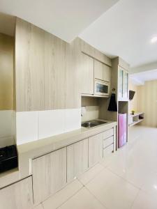 SunggalHozby Skyview Setiabudi的厨房配有白色橱柜和冰箱。