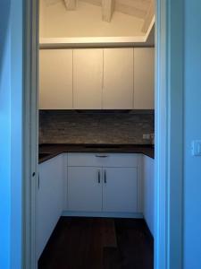 TrariviVilla Tilly的空的厨房,有白色的橱柜和蓝色的门