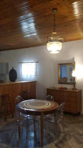 萨尔蒂Dino's Cottage的一间带桌椅和天花板的用餐室