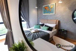马六甲The Quartz Melaka By I Housing的一间卧室配有一张带绿色枕头的床