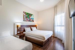 提比里亚特拉维夫度假屋酒店的酒店客房设有两张床和窗户。