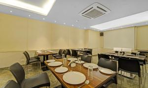 钦奈Upar Hotels Cinecity Kodambakkam RAGHAVENDRA MANDAPAM的一间带桌椅和天花板的用餐室