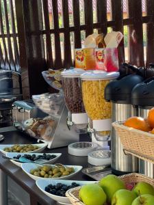 北马马亚-讷沃达里Hotel Sweet的餐桌,盘子上放着食物和水果碗