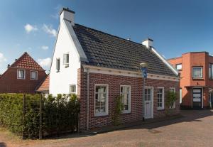 WinsumKarakteristiek huis in centrum Winsum met nieuwe badkamer的白色和红色的房子,有黑色的屋顶