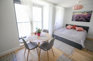 ĶesterciemsSeaside apartment Albatross, spa and pool的卧室配有一张床和一张桌子及椅子