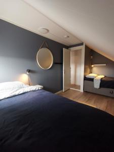 安德内斯Andenes Sentrum Apartment的卧室配有一张床,墙上设有镜子