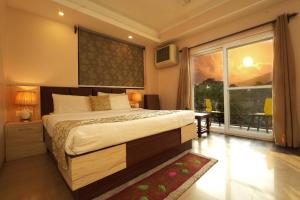 达兰萨拉Hotel 360 by D'Polo Dharamshala的一间卧室设有一张大床和一个大窗户