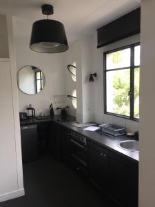 布洛涅-比扬古Numéro 5的一间黑色的厨房,配有水槽和窗户