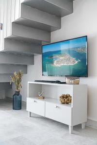 希贝尼克Krapljunka, otok Krapanj的白色的客厅,墙上配有电视