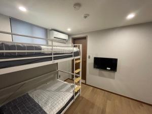 首尔Hao Guesthouse in Hongdae的客房设有双层床和平面电视。