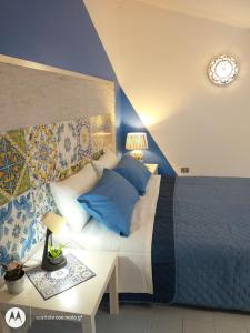 庞特卡格纳诺IDA S Apartament的一间卧室配有一张带蓝色枕头的大床