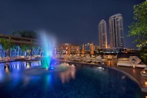 曼谷曼谷里瓦苏里亚酒店 - SHA Extra Plus的一座城市的游泳池,晚上有喷泉