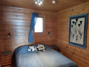 库萨莫Sininen Hetki Cottage的小木屋内一间卧室,配有一张床