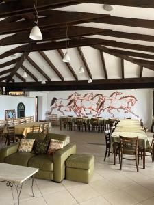 赛比什桦树乡村俱乐部酒店的大房间设有桌子和沙发,并拥有马壁画