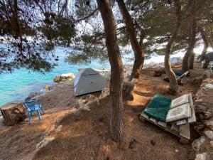 希马拉Pine Side Camp的水边海滩上的帐篷和椅子