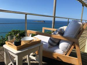 蒙达卡Adosado en la costa con excelentes vistas al estuario de Urdaibai的海景阳台上的椅子